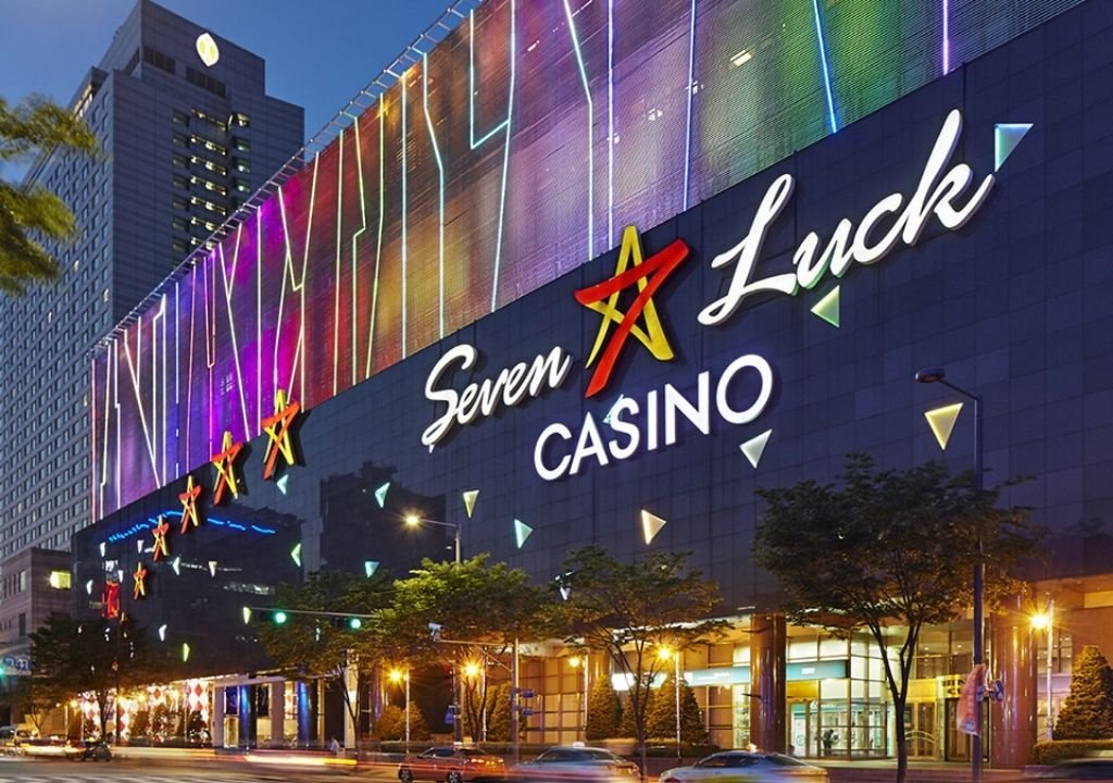 그랜드코리아레저(GKL)가 운영하는 세븐럭 카지노 코엑스점 야경 외관, 네온 조명 아래 ‘Seven Luck Casino’ 간판이 빛나는 모습