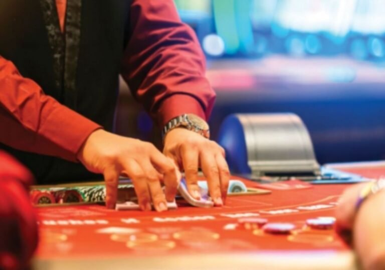 “카지노 딜러가 테이블 위에서 칩과 카드를 정리하는 모습 — 강원랜드와 MGM 오사카의 경쟁을 상징하는 장면”